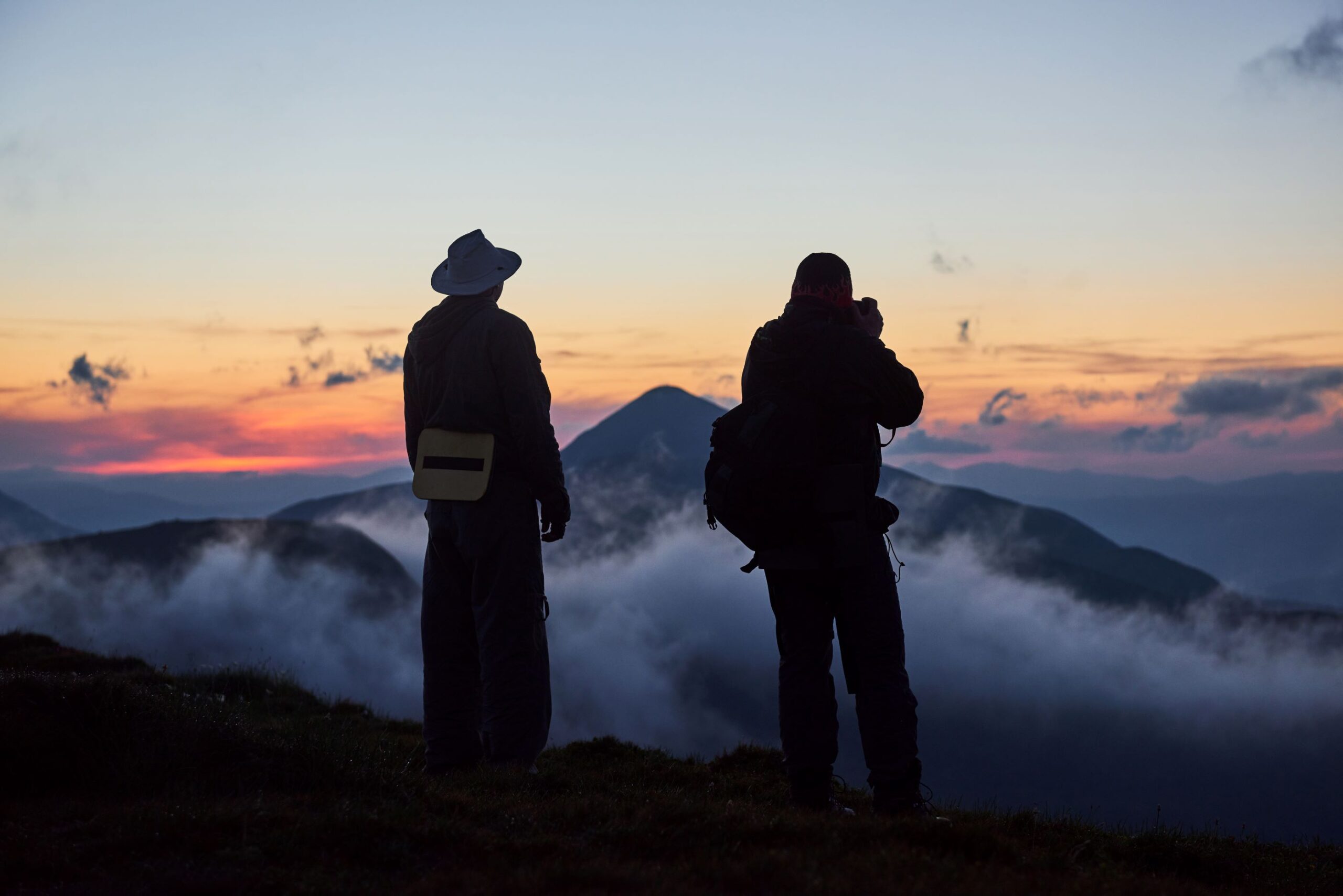 man-standing-on-a-ledge-of-a-mountain-enjoying-th-2023-11-27-05-29-06-utc